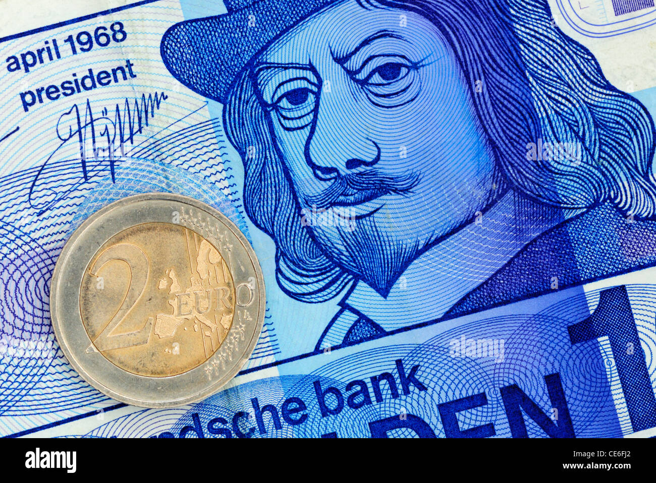 10 niederländische Gulden Banknote und 2-Euro-Münze Stockfoto