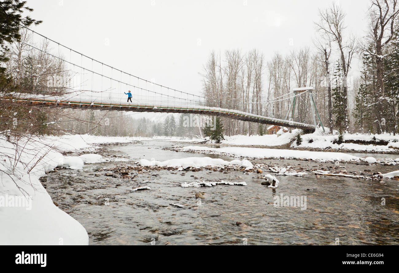 Eine Frau, überqueren die Tawks-Foster-Hängebrücke über den Methow River in der Nähe von Mazama, Washington, USA. Stockfoto