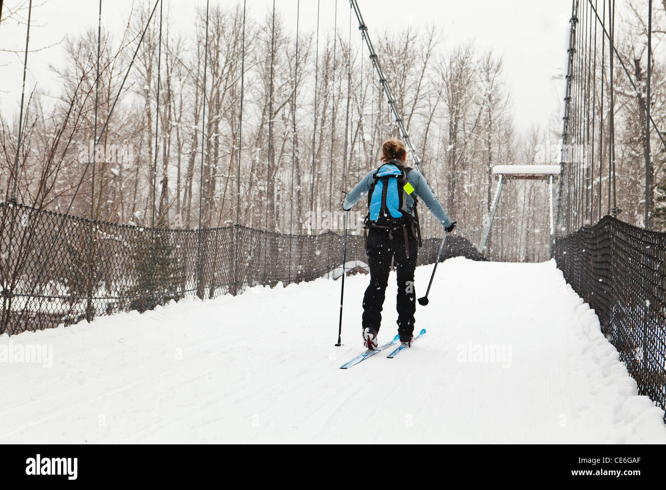 Eine Frau, überqueren die Tawks-Foster-Hängebrücke über den Methow River in der Nähe von Mazama, Washington, USA. Stockfoto