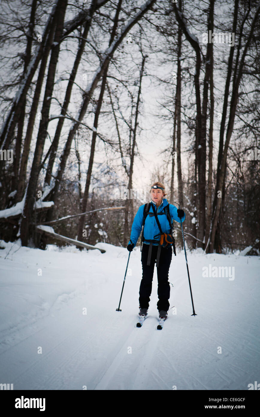 Eine Frau Langlaufen auf einer präparierten Trail am frühen Abend. Mazama, Washington, USA. Stockfoto