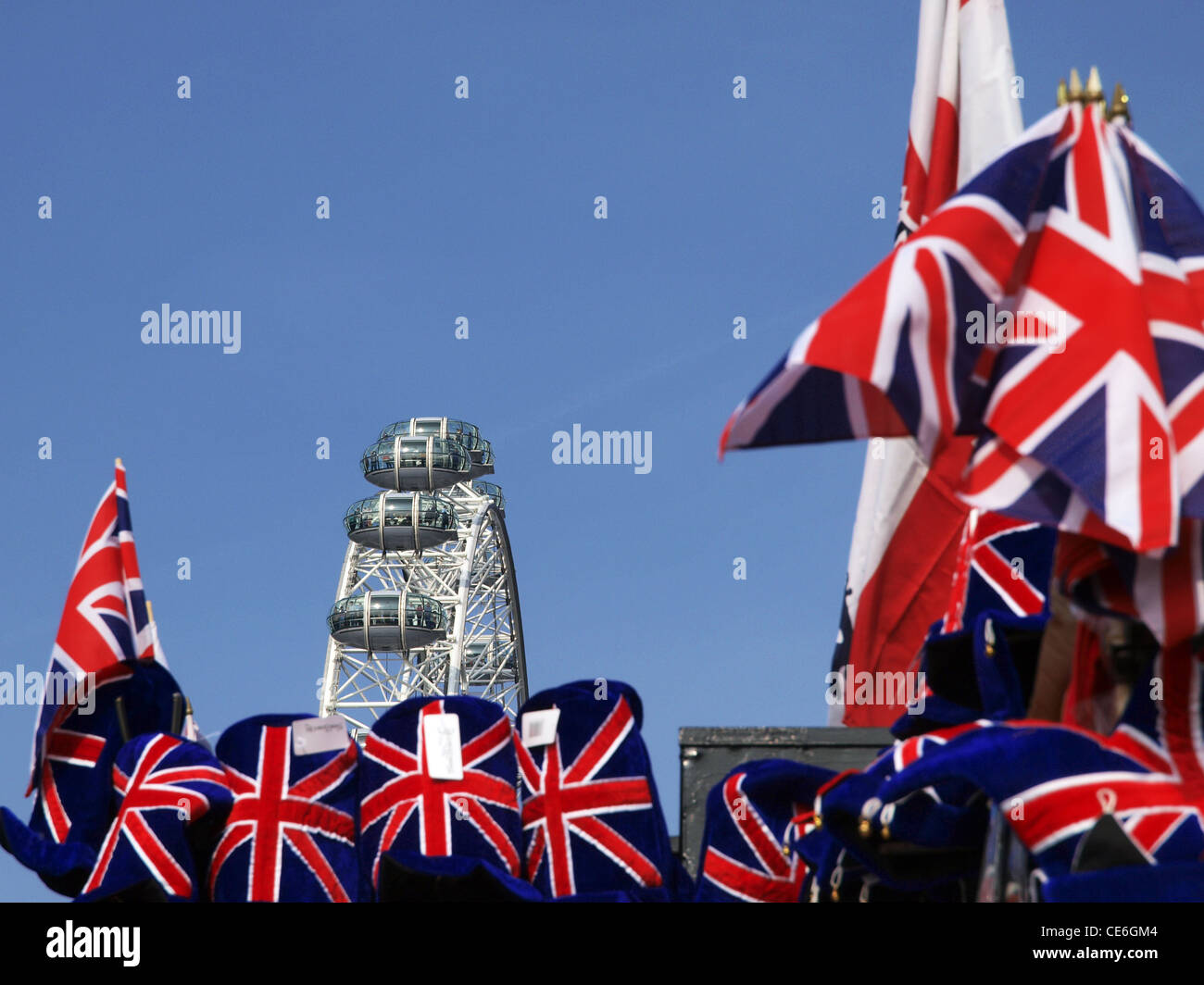 Ein im Fokus London Eye überragt ein Andenken Stall mit Union Jack-Flaggen und Hüte. Stockfoto