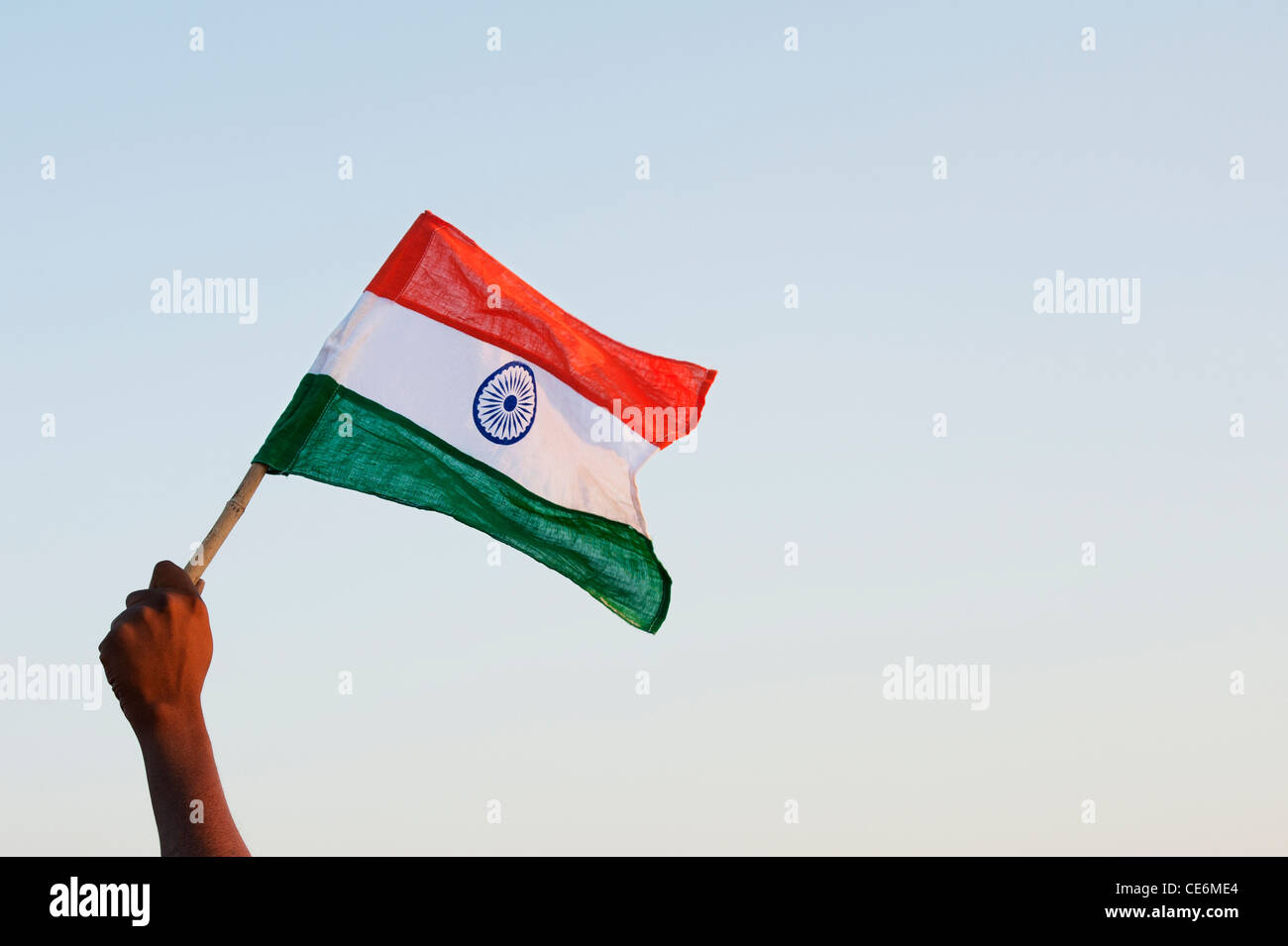 Indische mans Hände halten eine indische Flagge vor einem blauen Himmel. Indien Stockfoto