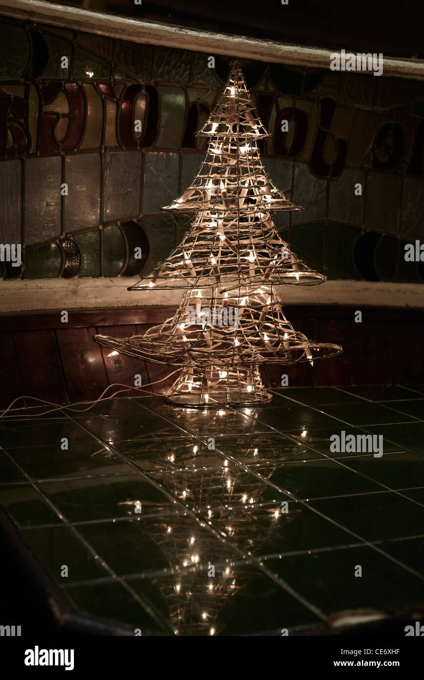 Weihnachtsbaum beleuchtet im Pub-Fenster Stockfoto