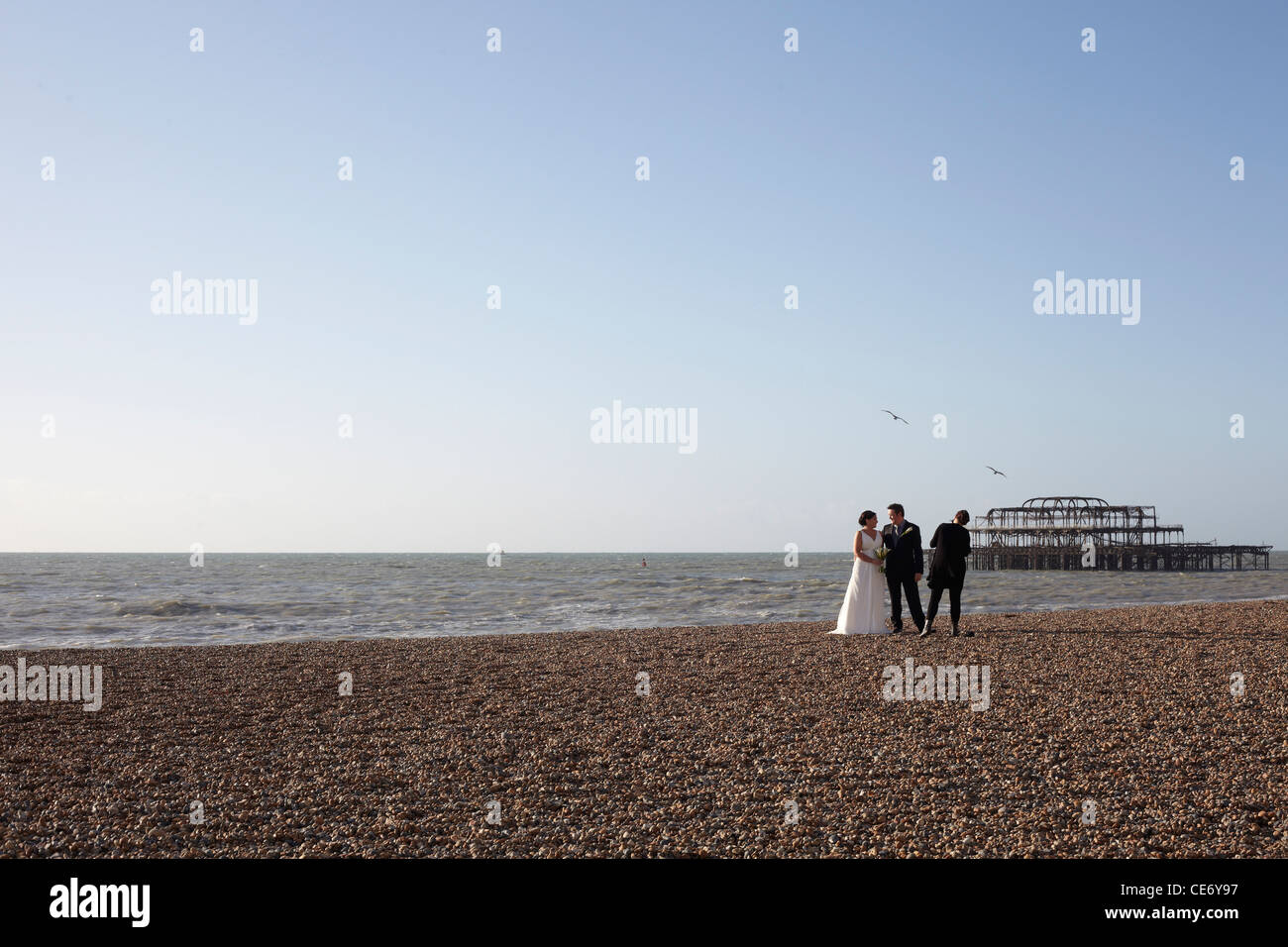Frisch verheiratetes Paar, Hochzeitsfotos, aufgenommen am Strand von Brighton Stockfoto