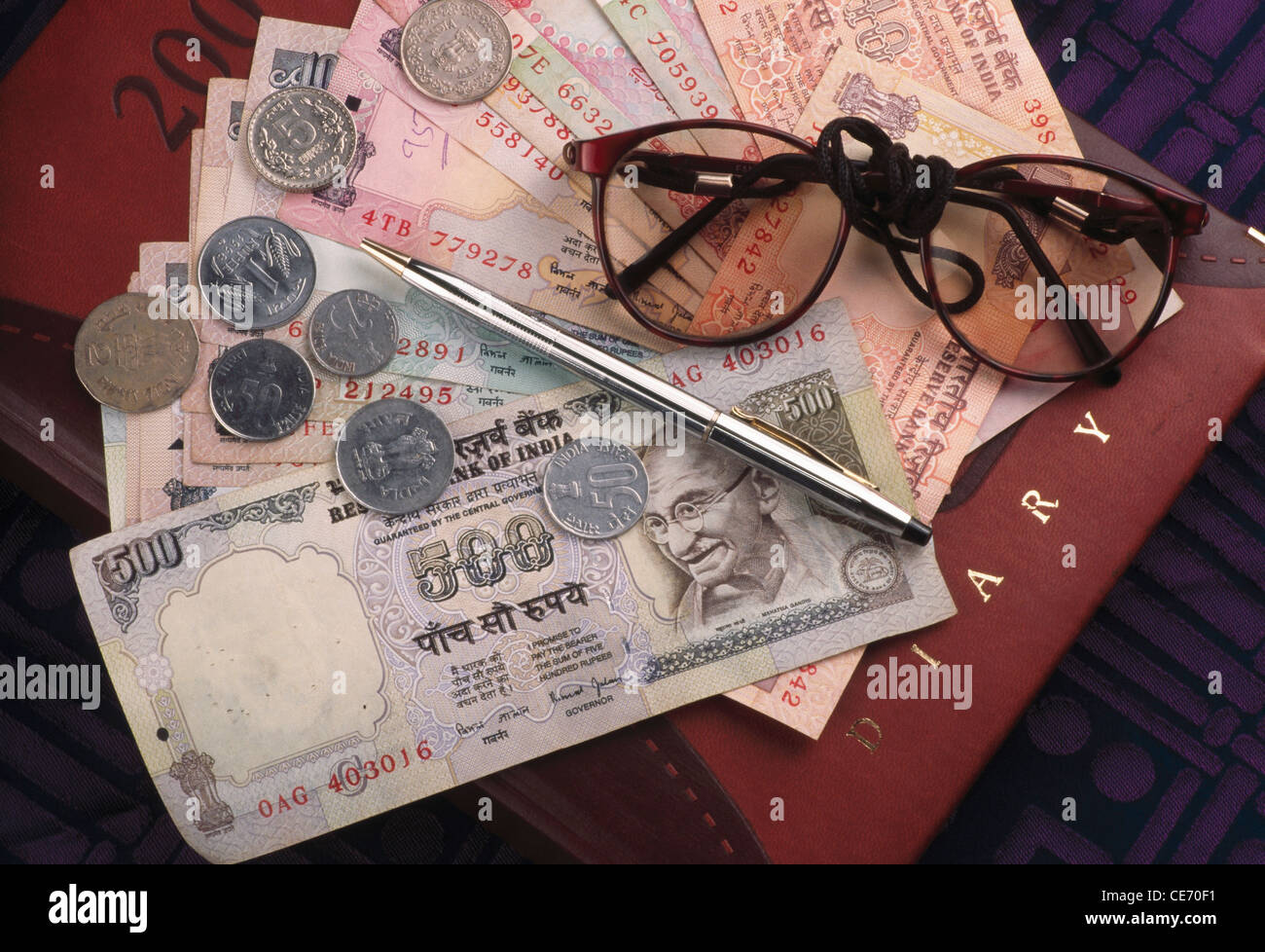 SSK 83910: Konzept Einsparungen Wirtschaft Business Konten Währung indische Papiergeld Noten Münzen Stift Tagebuch Brille Indien Stockfoto