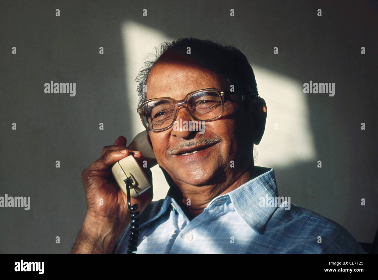 Indischer alter älterer Mann mit Brille, der am Telefon spricht; Indien; Asien; HERR#320 Stockfoto