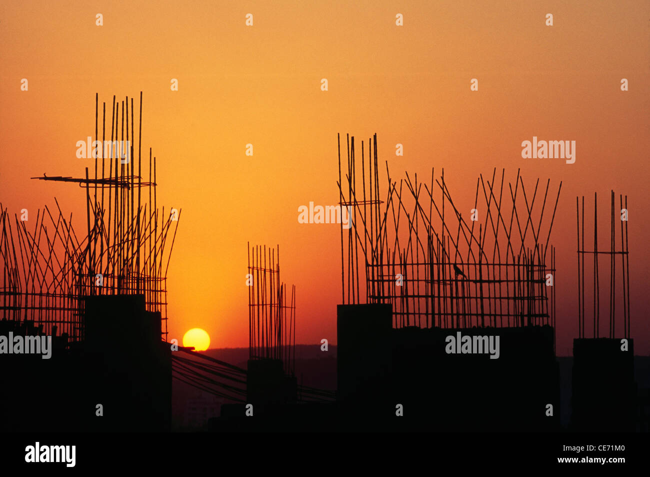 Sonnenuntergang hinter Säulen und Balken unter Bau Pune Maharashtra Indien Stockfoto