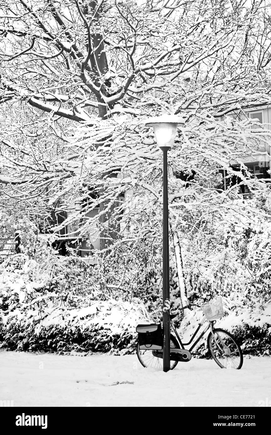 Streetview im Schnee mit Laternenpfahl und Fahrrad im Winter - schwarz / weiß Bild Stockfoto