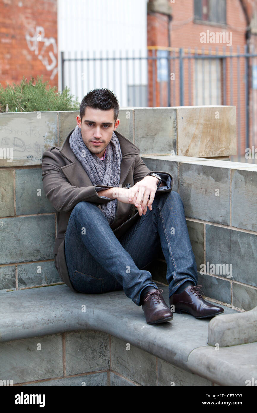 Männliches Modell fällt eine Pose in einem städtischen Umfeld in Leeds, West Yorkshire, England Stockfoto
