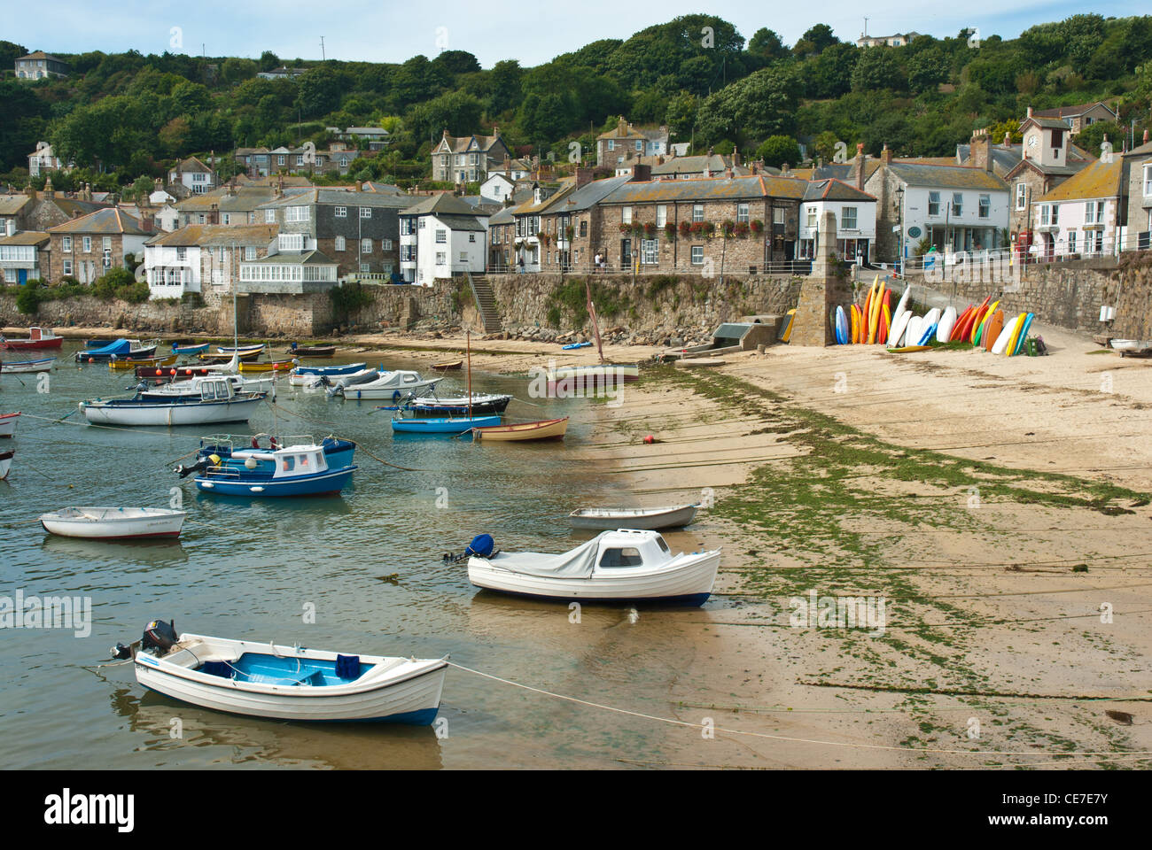 Dorf von Mousehole Cornwall mit Hafen und Strand mit bunten kleinen Booten im Sommer. Stockfoto