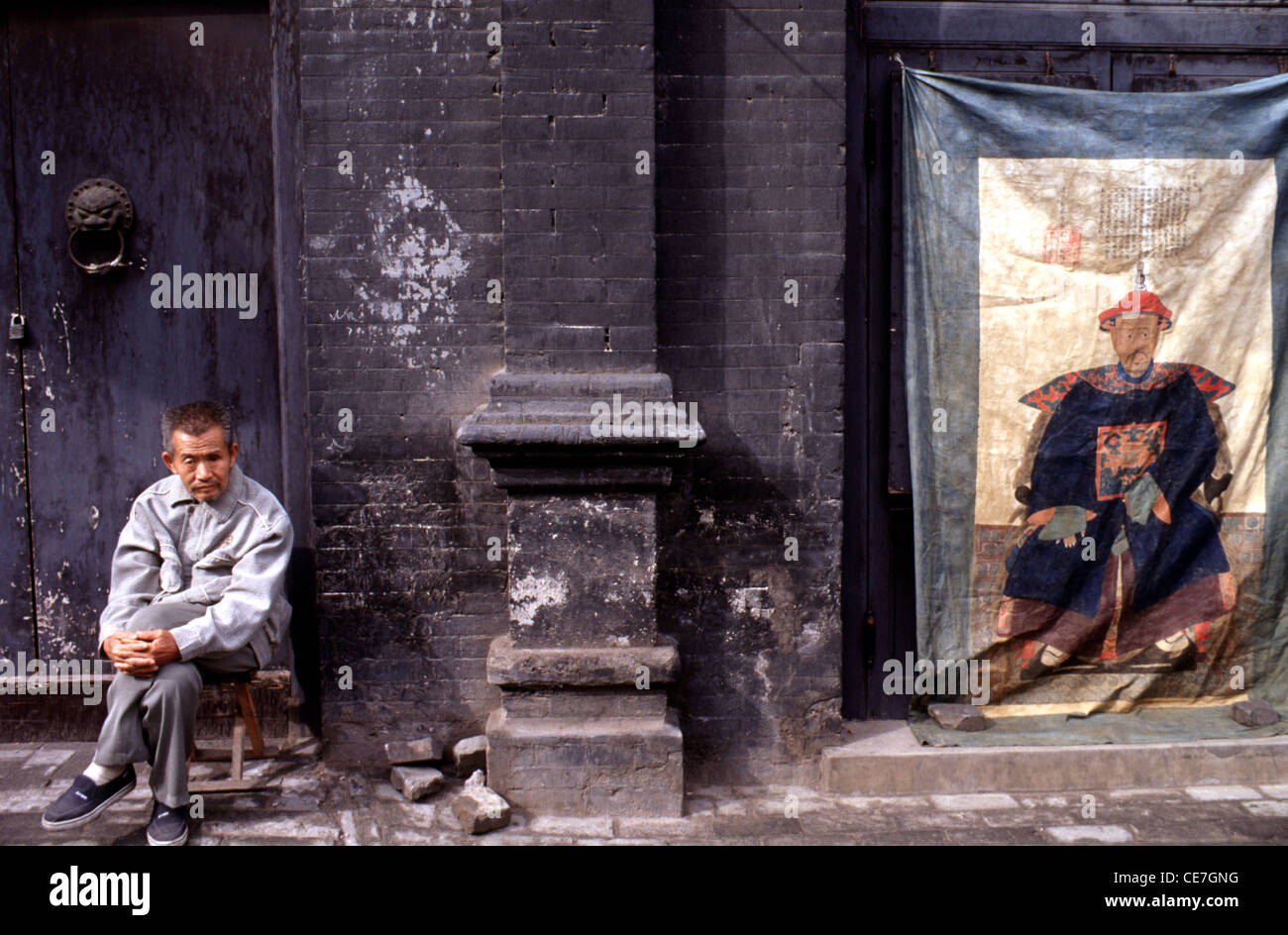 Chinesischer Mann in einer Hutong in der Gasse in der Stadt Beijing China sitzen Stockfoto Chinesischer Mann in einer Hutong in der Gasse in der Stadt Beijing China sitzen Stockfoto