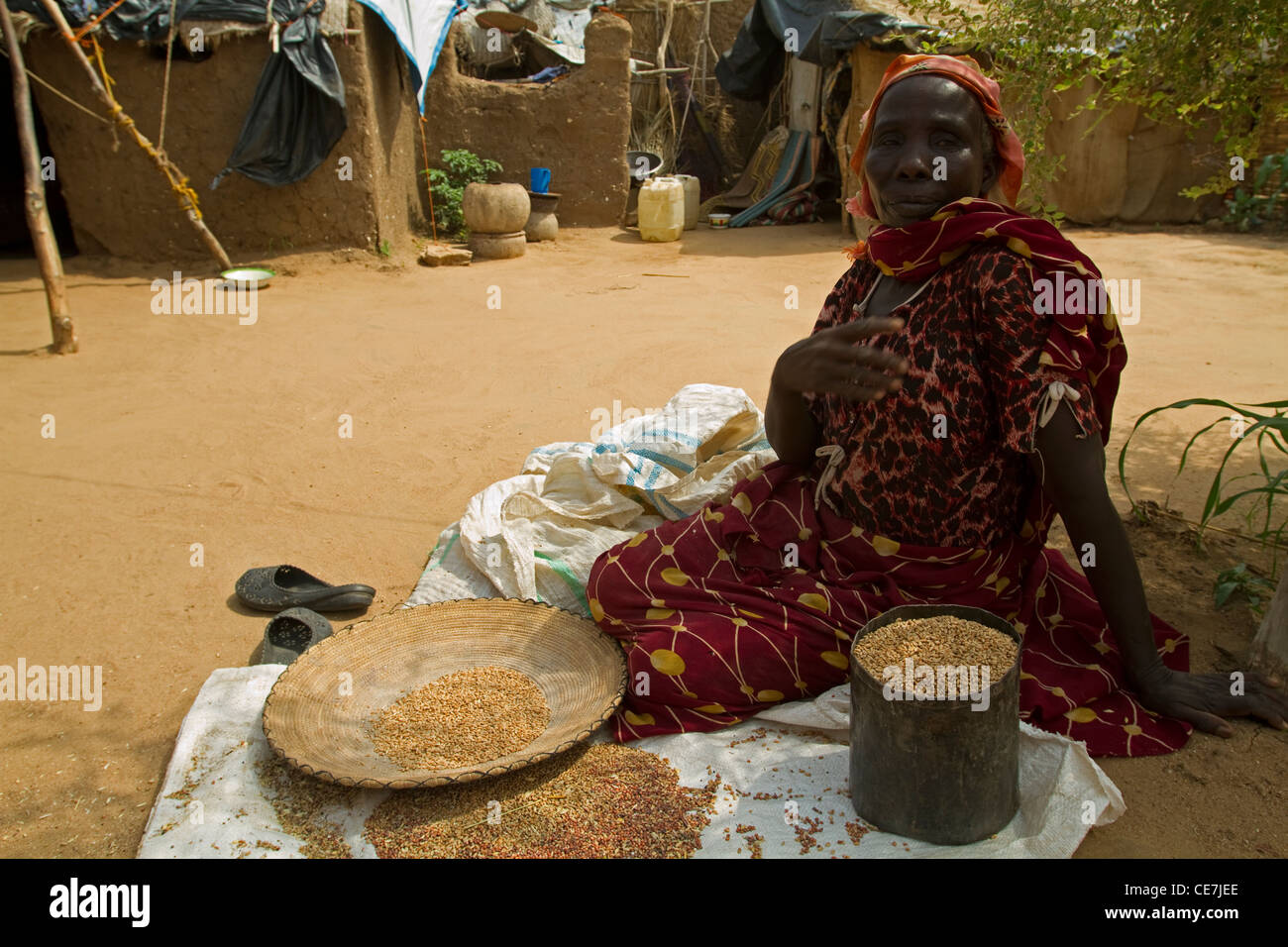 Sudanesische Flüchtling Frau Vorbereitung Getreide bekommt sie von humanitären Nahrungsmittelhilfe Darfur Sudan. Stockfoto