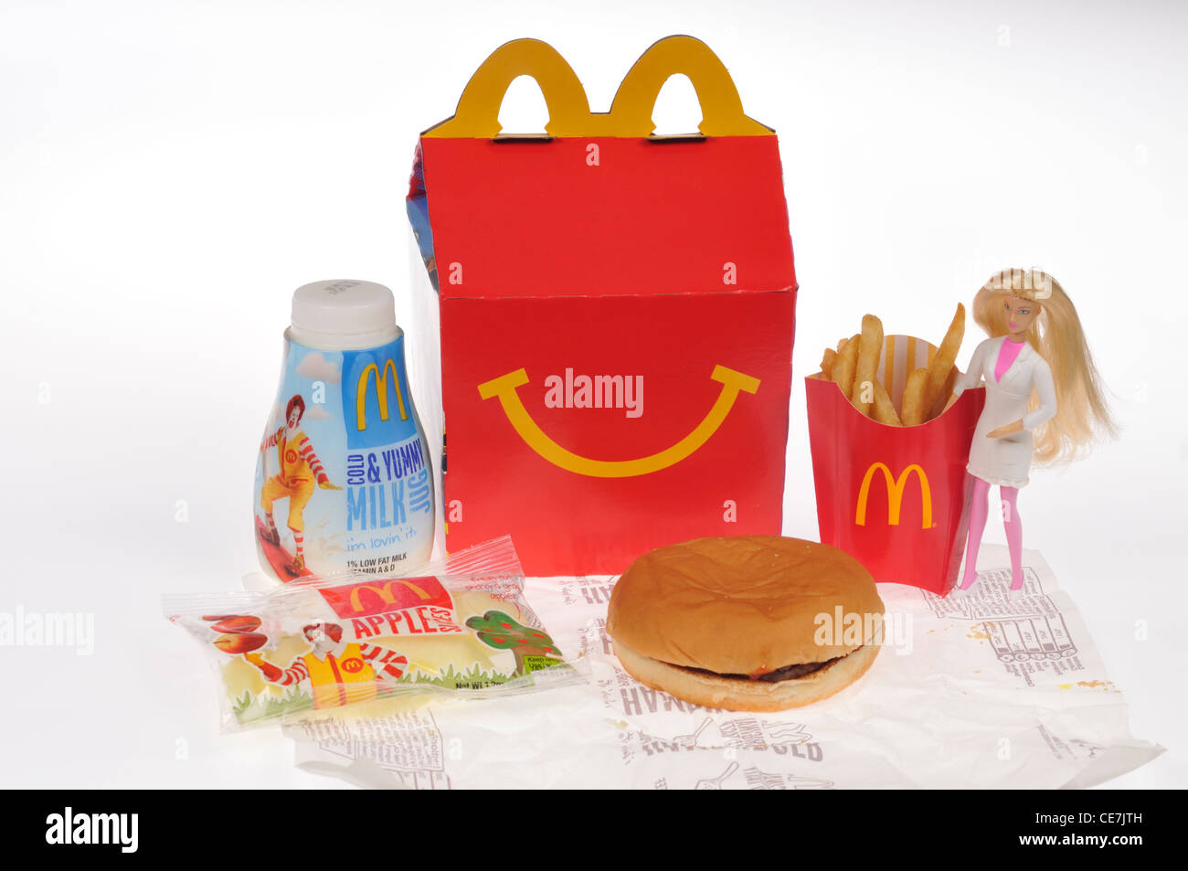 McDonald's Happy Meal-Box mit einen Burger, Pommes frites, Milch und Apple Wasseramseln und eine Barbie Puppe Spielzeug auf weißem Hintergrund Ausschnitt. USA Stockfoto
