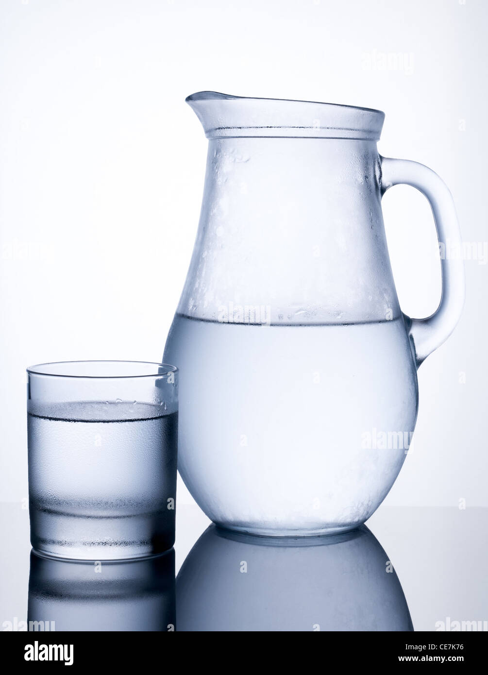 Krug mit klaren kalten Wasser mit Glas isoliert auf weißem Hintergrund Stockfoto