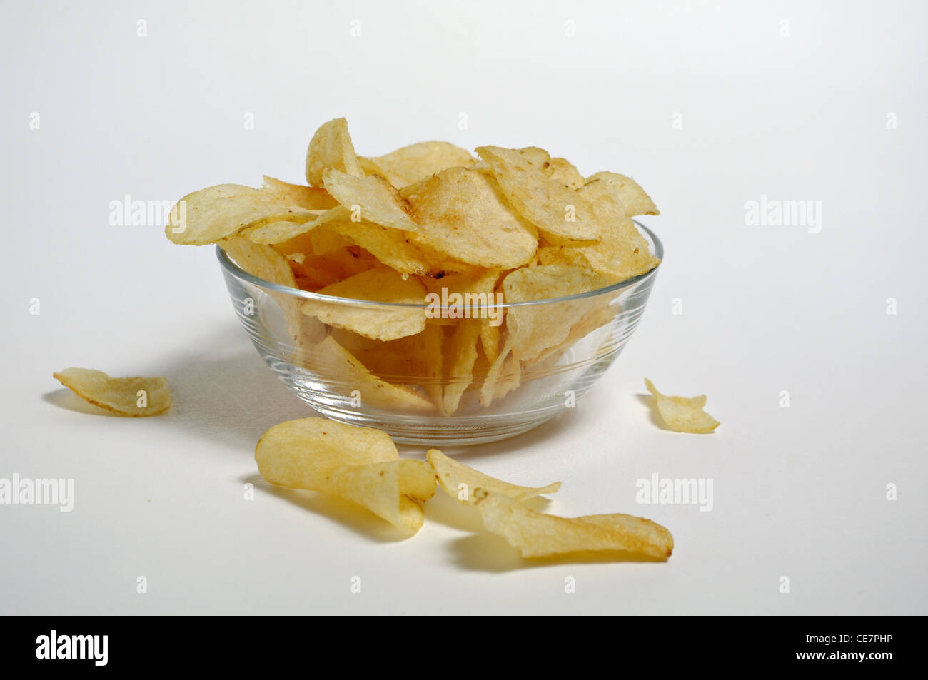 Kartoffel-Chips sitzen in eine Glasschüssel auf einem weißen Hintergrund. Stockfoto