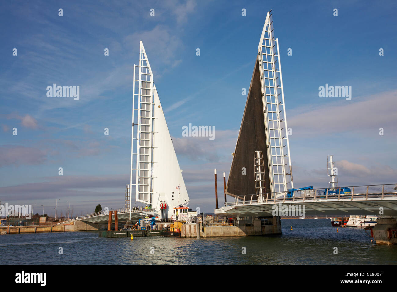 Prüfung der Öffnung der neuen twin Segel anheben Brücke über den Hafen von Poole in Poole, Dorset, Großbritannien mit dem Lastkahn durch - 2 Segel Brücke, Klapp Stockfoto