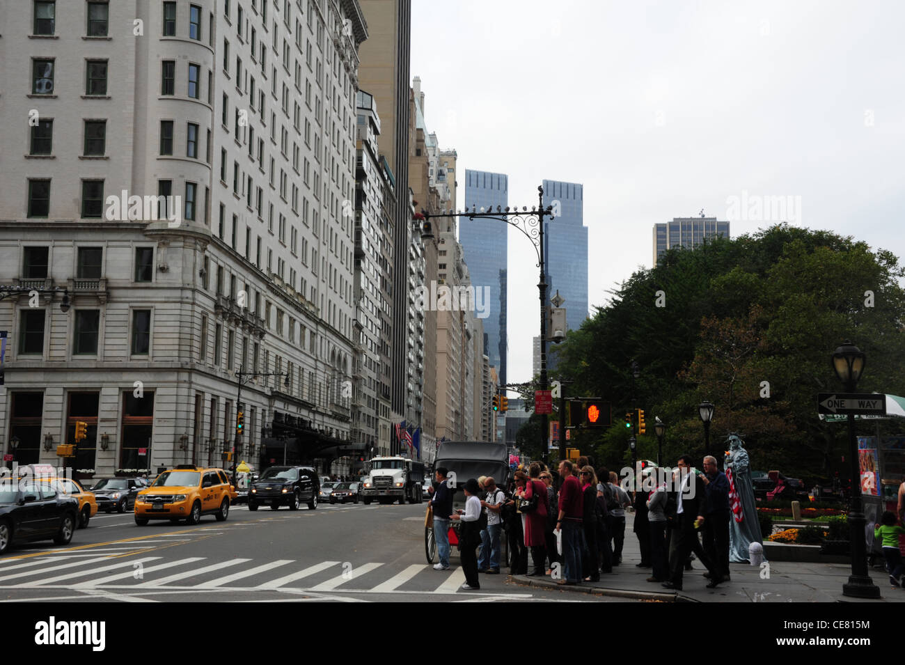 Grauen Himmel sehen, Plaza Hotel Times Warner, "Freiheitsstatue" Entertainer, viele Menschen West 59th Street in 5th Avenue in New York Stockfoto