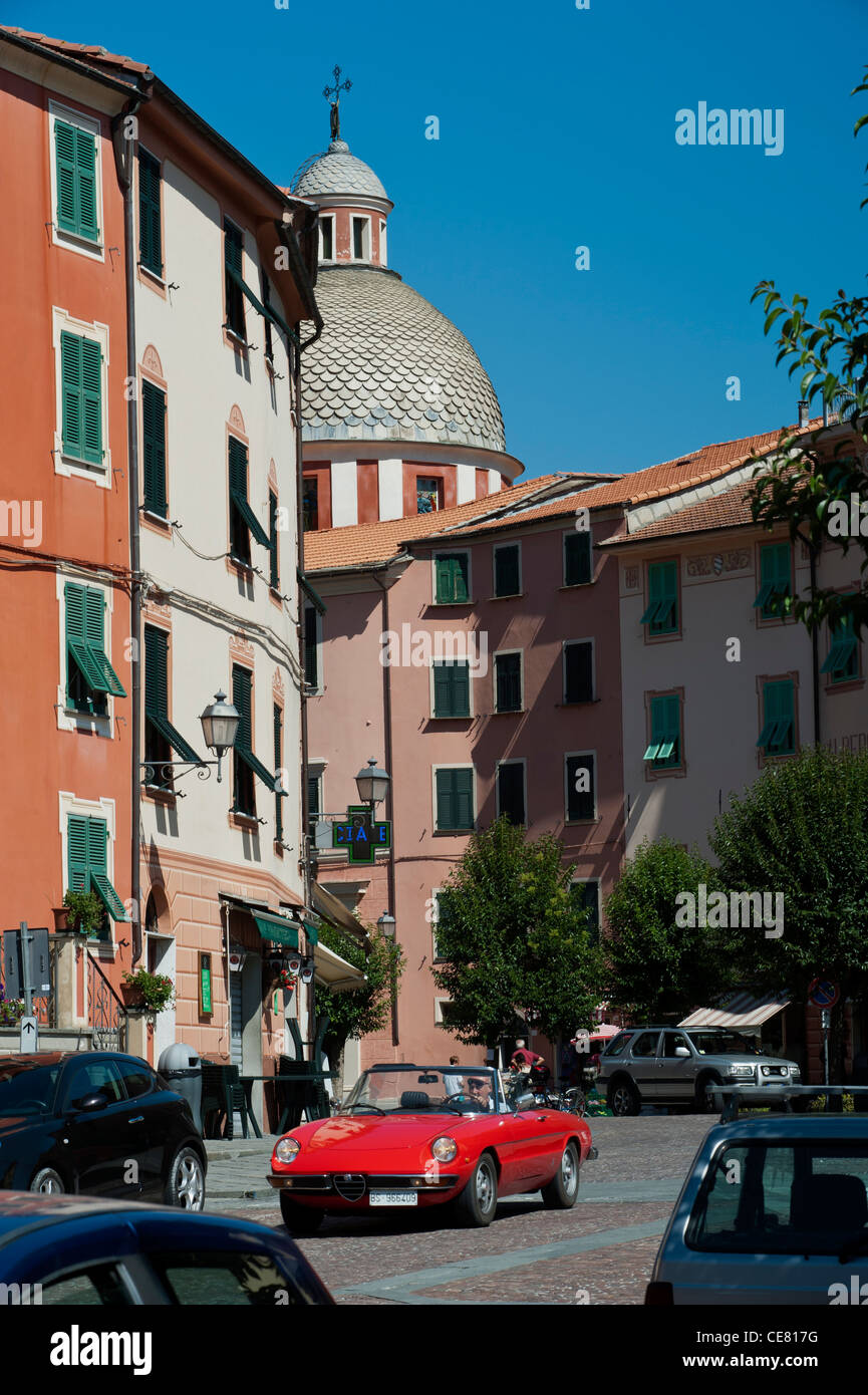 Ein roter Alfa Romeo-Sportwagen vor der Kirche San Filippo Neri, Varese Ligure. Val di Vara, Provinz La Spezia. Ligurien. Italien Stockfoto