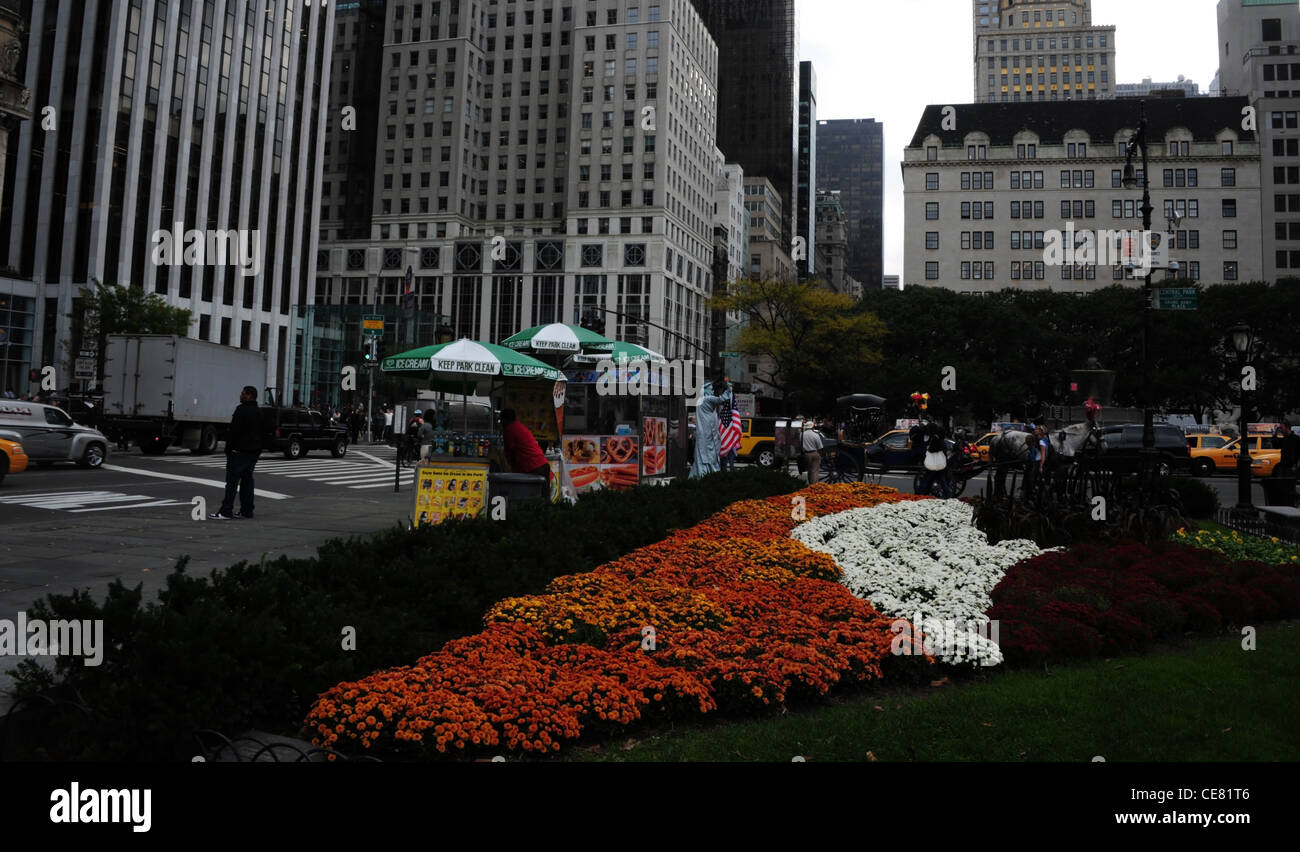 Grauen Himmel sehen orange weiße Blumenbeet, Leute, Bürgersteig Eis Stände, Wolkenkratzer, 5th Avenue, Grand Army Plaza, New York Stockfoto