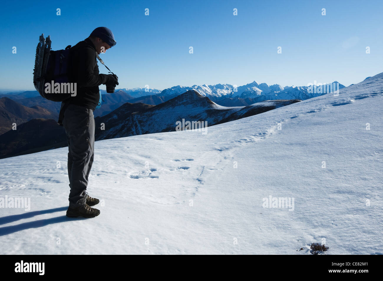 Mann mit Blick auf seine Digitalkamera, Pic De La Calabasse (2210 m), in der Nähe von Saint-Lary, zahlt Couserans, Ariege, Pyrenäen, Frankreich. Stockfoto