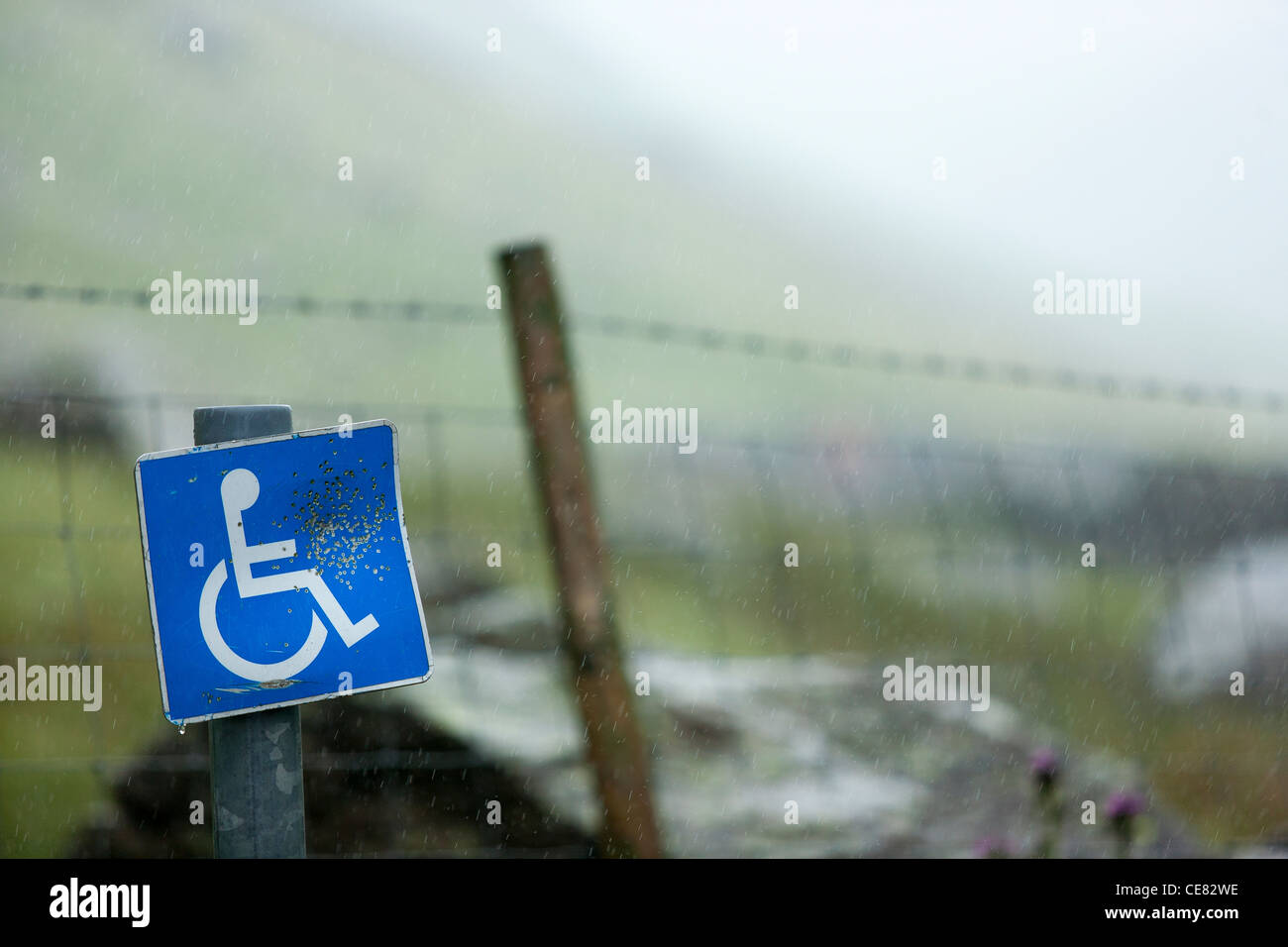 Ein Handicap, Parkplatz Schild, die mit einem Luftgewehr in die Landschaft der Grafschaft Cumbria im Lake District verwüstet worden. Stockfoto