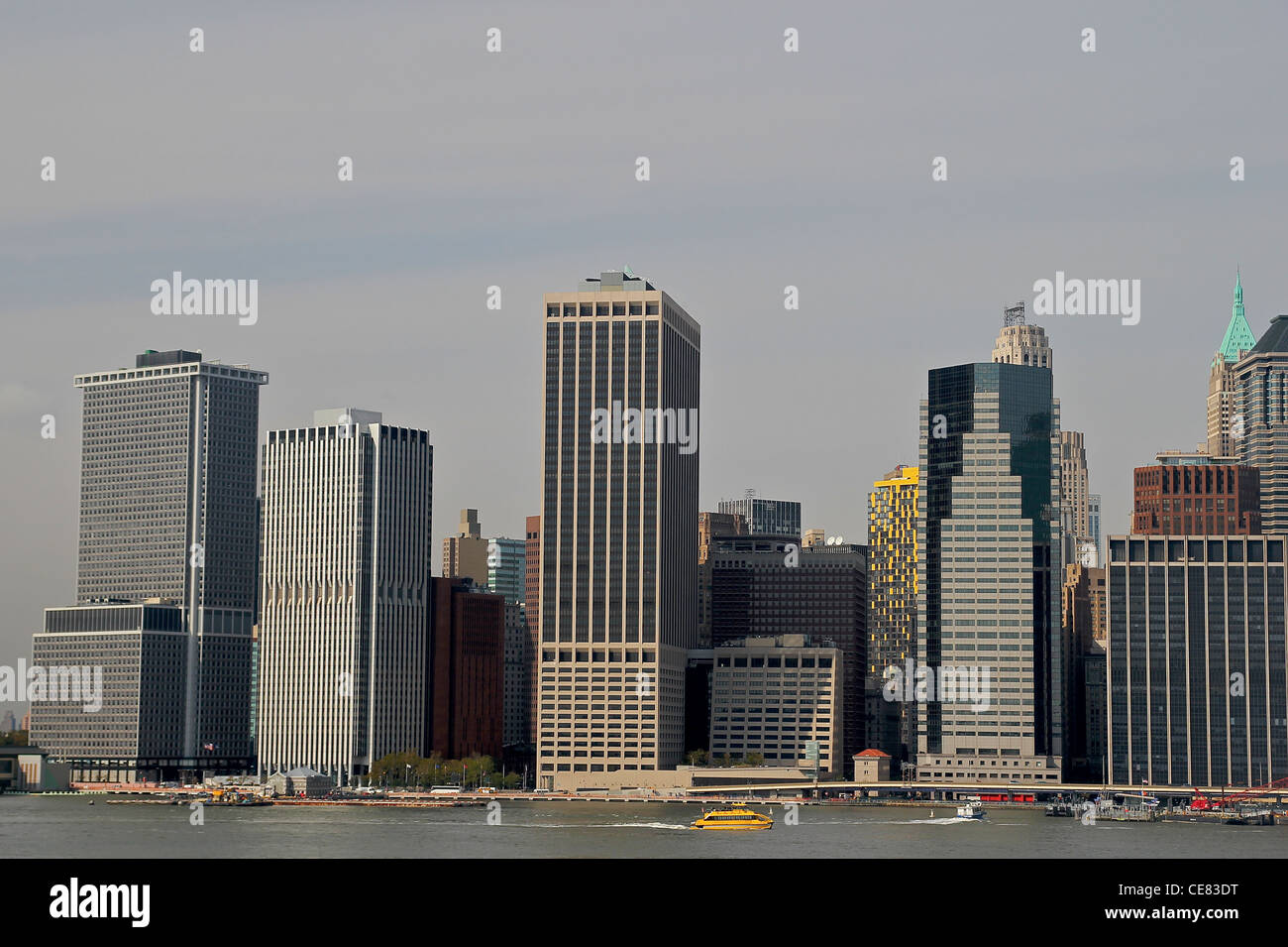 Blick auf Lower Manhattan von Brooklyn Heights Promenade als gelbes Boot geht in den East River. Stockfoto