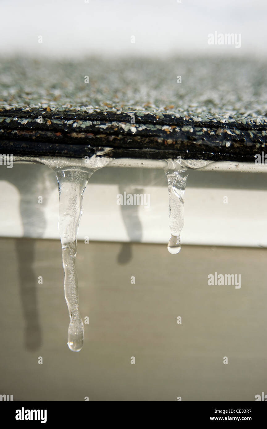 Nahaufnahme der schmelzende Eiszapfen auf Dach. Stockfoto