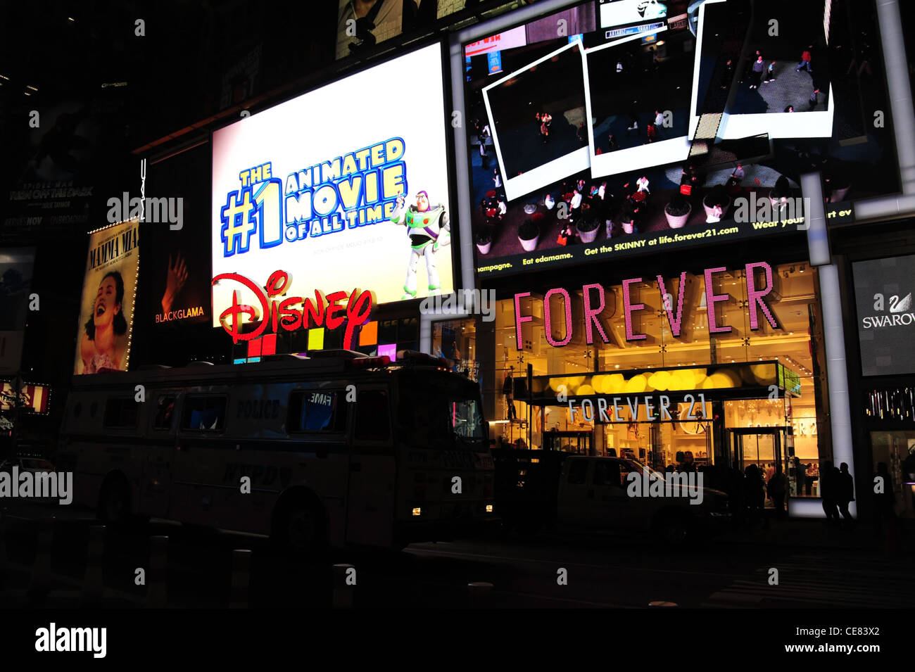 Nacht-Ansicht Menschen zu Fuß, Bus bewegte Vergangenheit, Neon Fassaden Forever 21 Kleidung Boutique, Disney Store, 7th Avenue, New York Stockfoto