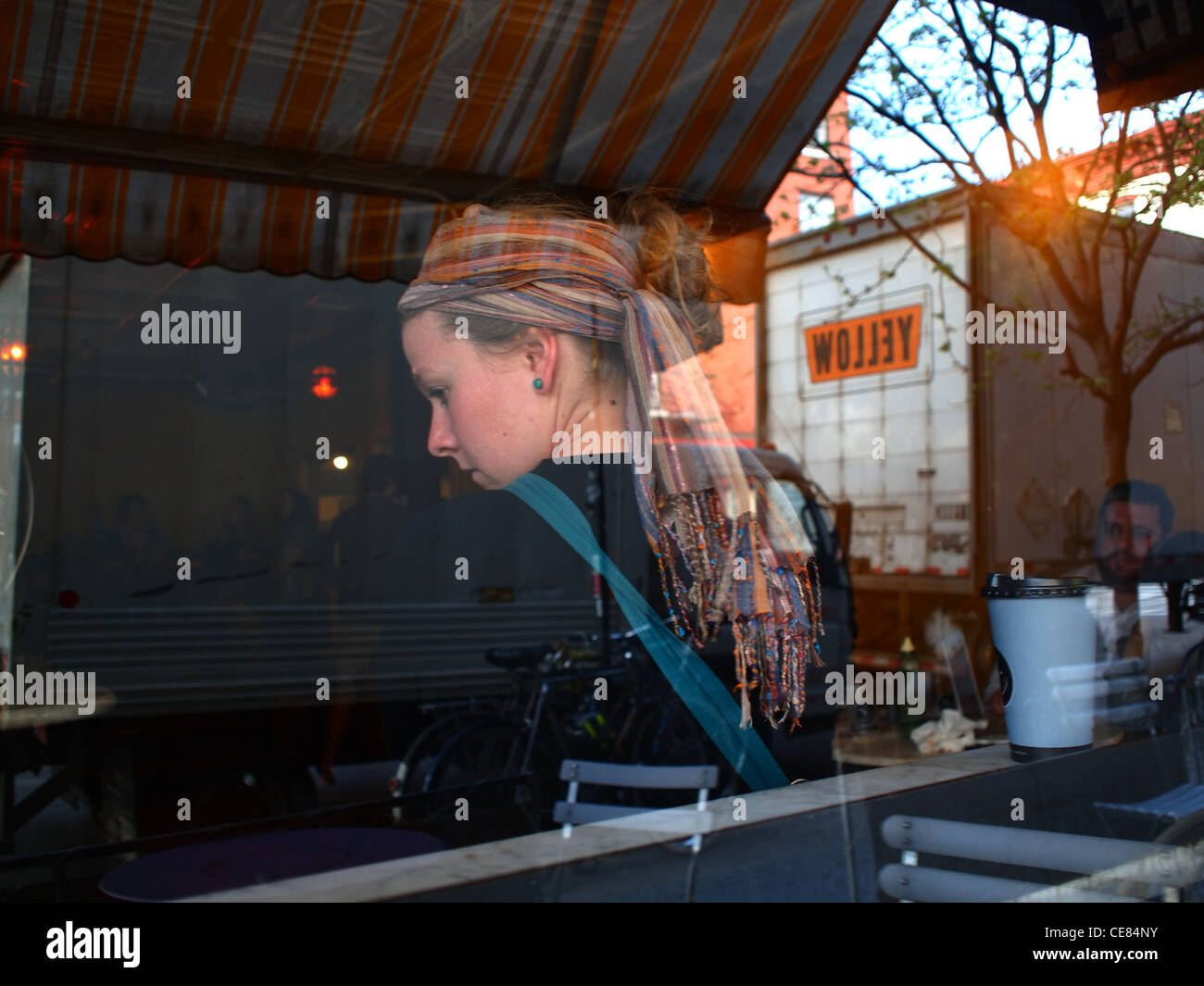 Junge Frau im Fenster mit Reflexionen, Verb-Coffee-Shop, Brooklyn, New York Stockfoto