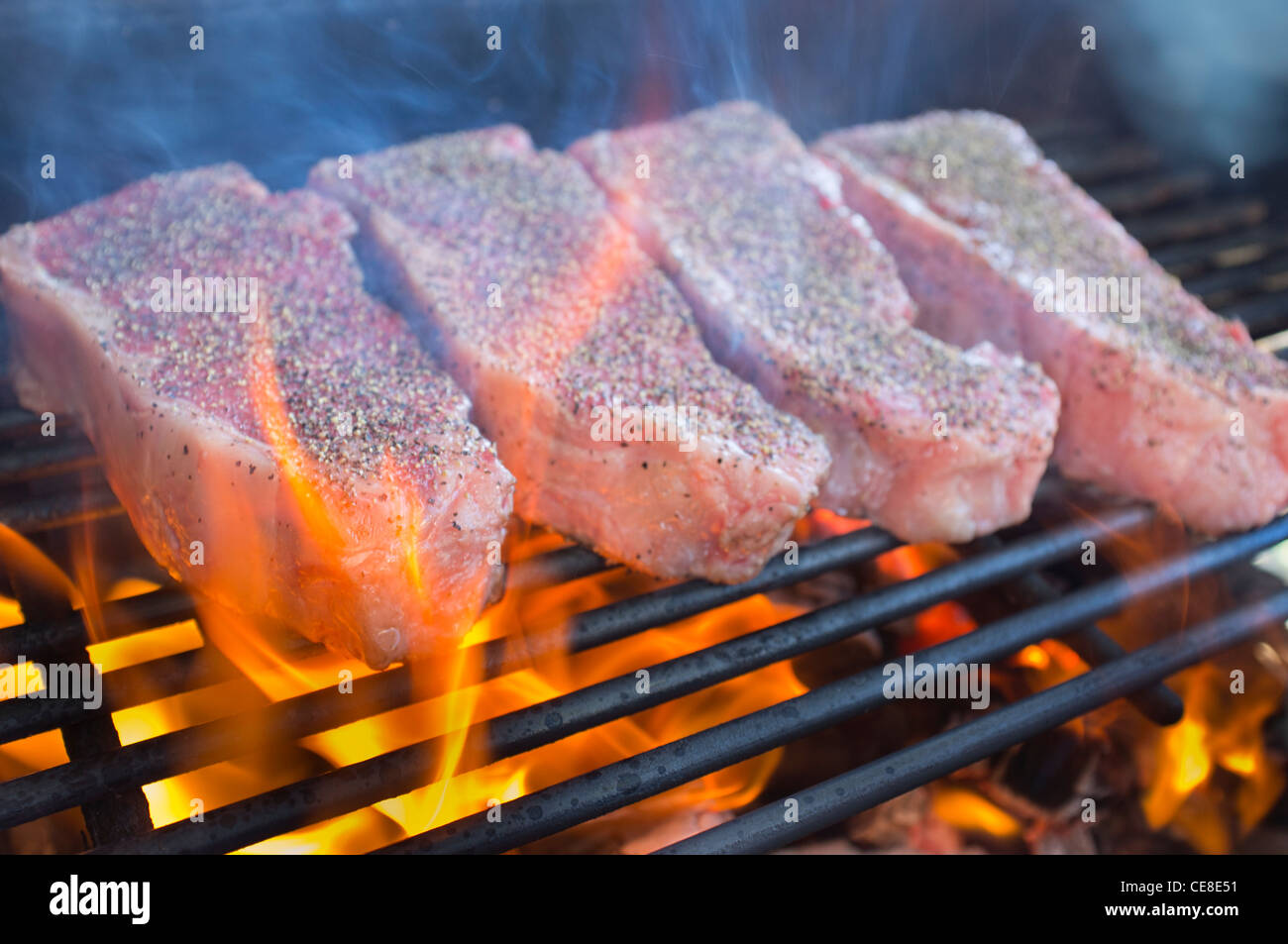 Erfahrene Rindfleisch Streifen Lende Steaks gegrillt über heiße Feuerstelle  Grill Stockfotografie - Alamy