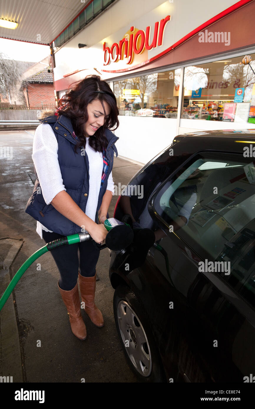 Teenager-Mädchen füllen ihr Auto mit Benzin an der Tankstelle, UK Stockfoto