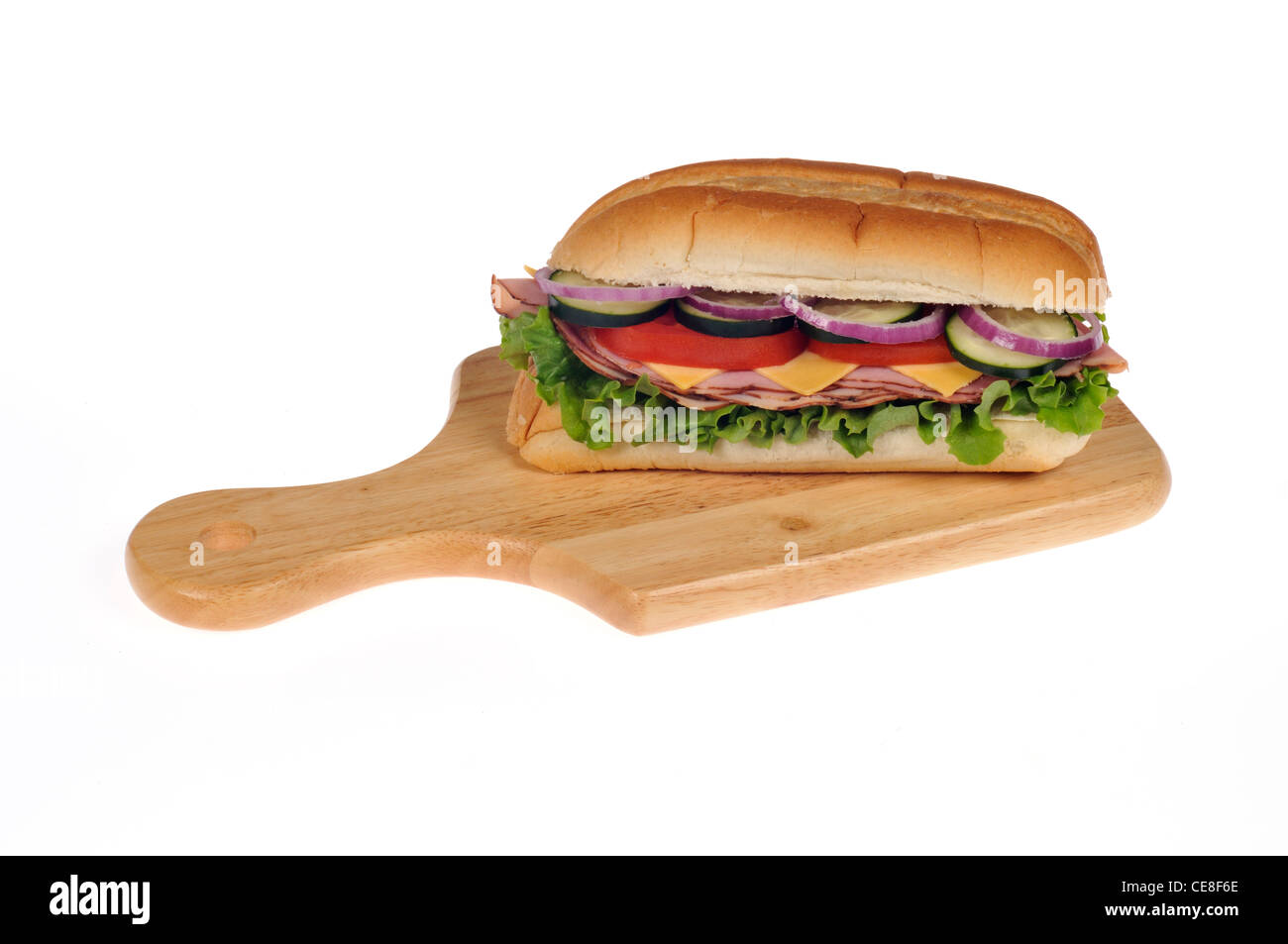 Schinken, Salat mit Käse deli Sandwich oder sub mit Salat, Tomaten, Zwiebeln und Gurken auf einem Holz Schneidebrett auf weißem Hintergrund Stockfoto