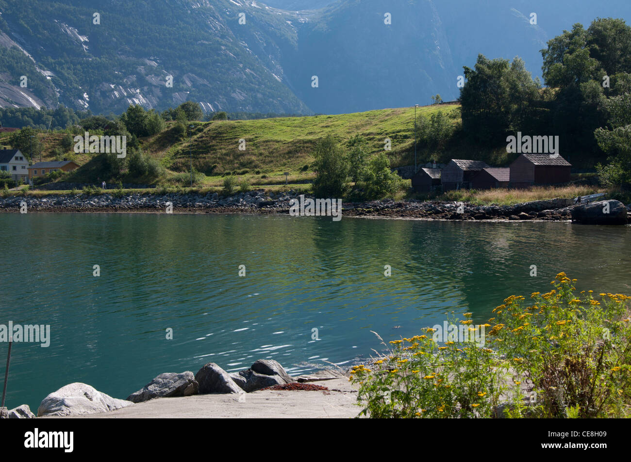 Eidfjord Norwegen Blick über Wasser in Richtung Bootshäuser am Rand des Wassers Stockfoto