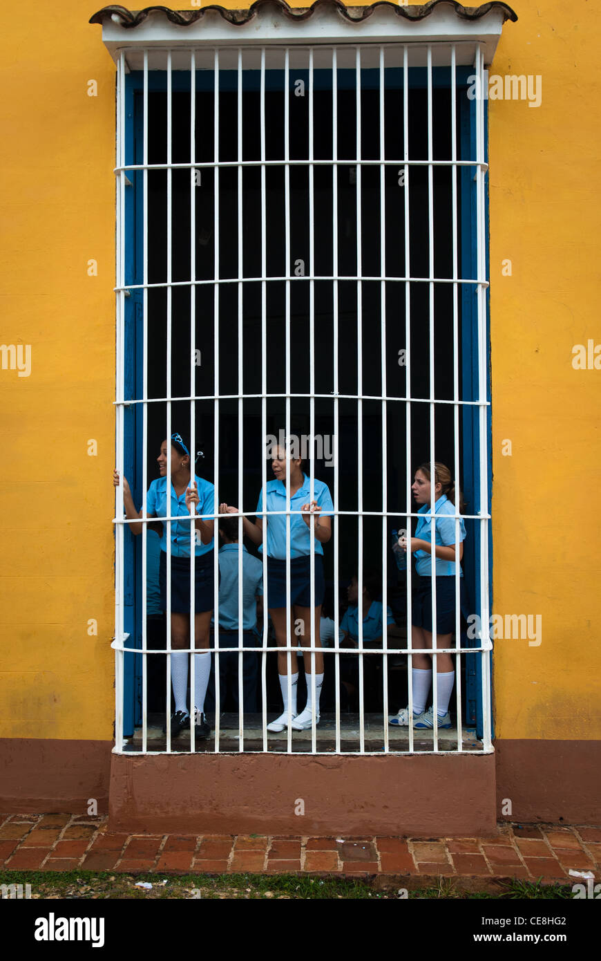 Schulmädchen stehen hinter den Gittern eines Schule-Fensters Stockfoto
