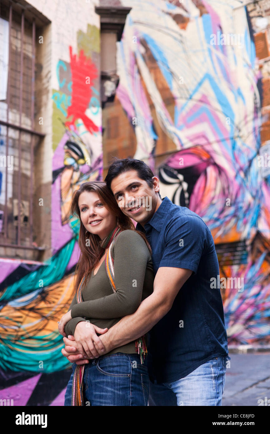 Junges Paar, umarmen, mit Gasse Straßenkunst im Hintergrund. Hosier Lane, Melbourne, Victoria, Australien Stockfoto
