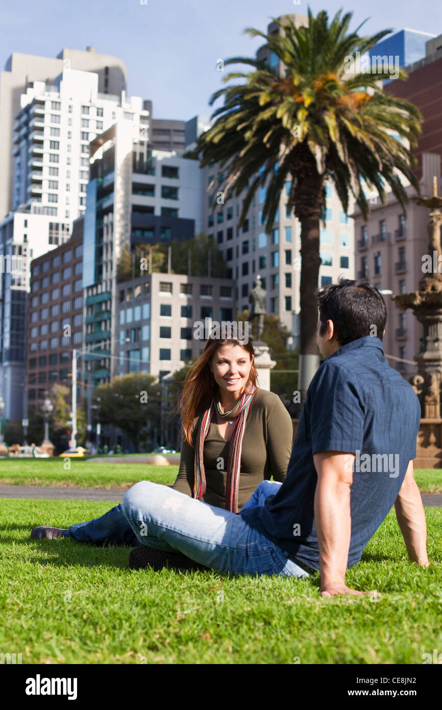 Junges paar entspannende im Park mit Skyline der Stadt im Hintergrund. Gordon-Reserve, Melbourne, Victoria, Australien Stockfoto