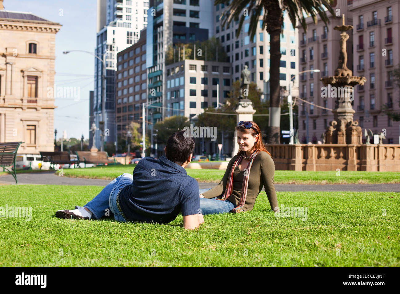 Junges paar entspannende im Park mit Skyline der Stadt im Hintergrund. Gordon-Reserve, Melbourne, Victoria, Australien Stockfoto