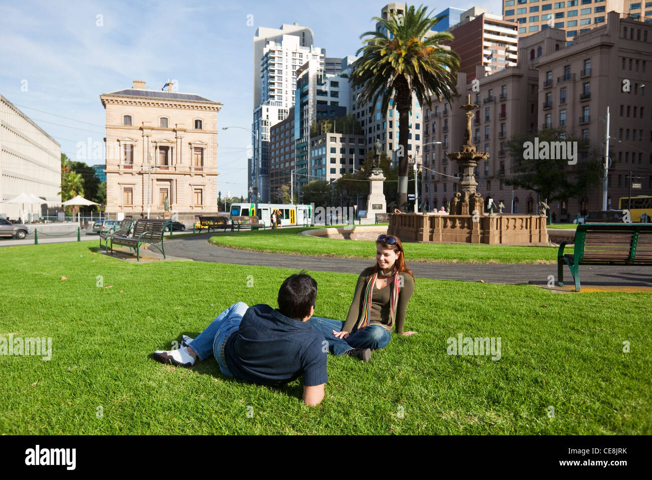 Junges paar entspannende im Park mit Skyline der Stadt im Hintergrund. Gordon-Reserve, Melbourne, Victoria, Australien Stockfoto