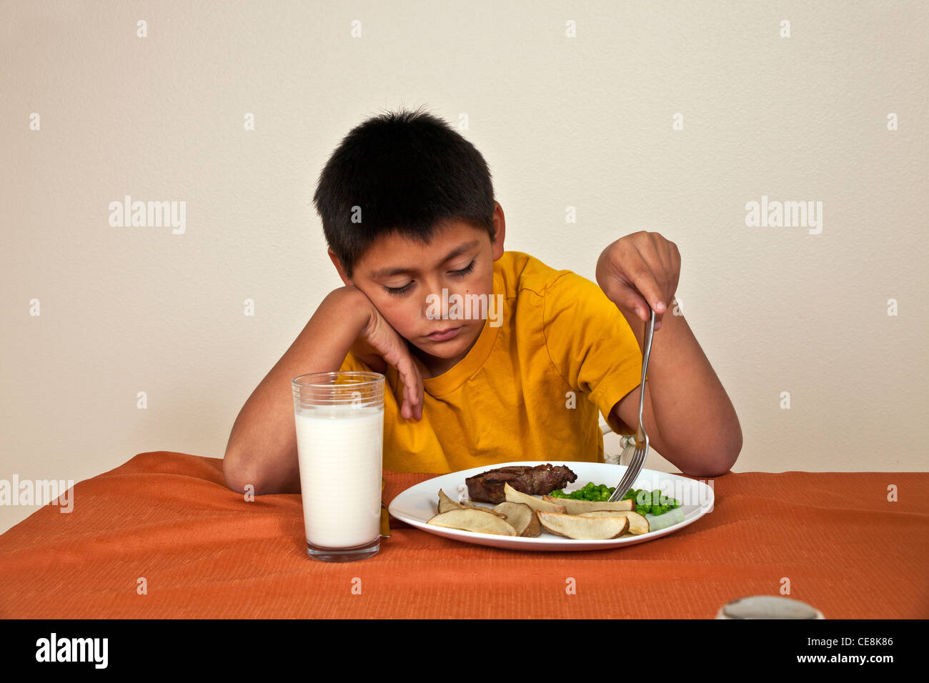 Willensstark hartnäckige 10-11 Jahre alten Hispanic junge am Tisch sitzen will nicht Herr © Myrleen Pearson zu essen Stockfoto