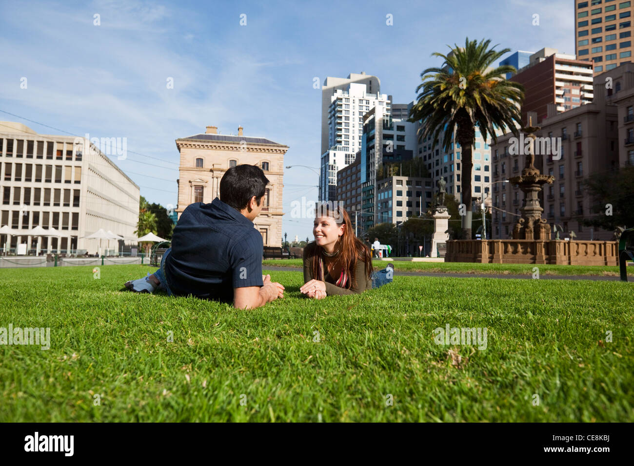 Junges paar entspannende im Park mit Skyline der Stadt im Hintergrund. Gordon-Reserve, Melbourne, Victoria, Australien Stockfoto