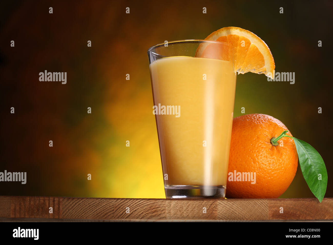 Orangen und Glas Saft auf einem Holztisch. Stockfoto