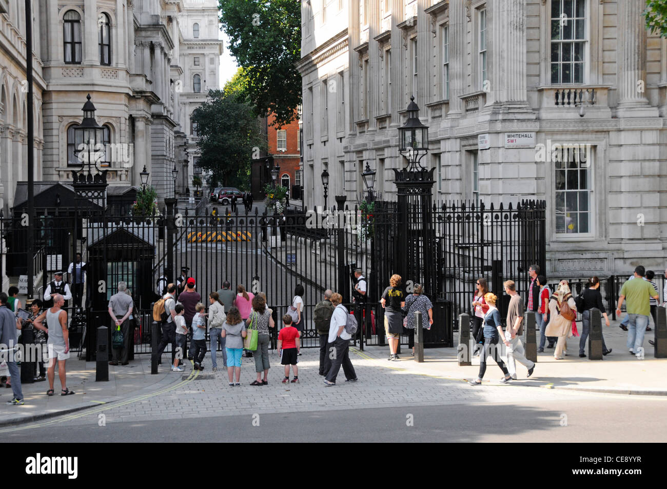 Touristen auf Gehwegen vor der Downing Street vor Stahlsicherheitstoren, kontrolliert von bewaffneten Metropolitan Police Officers in London England Stockfoto