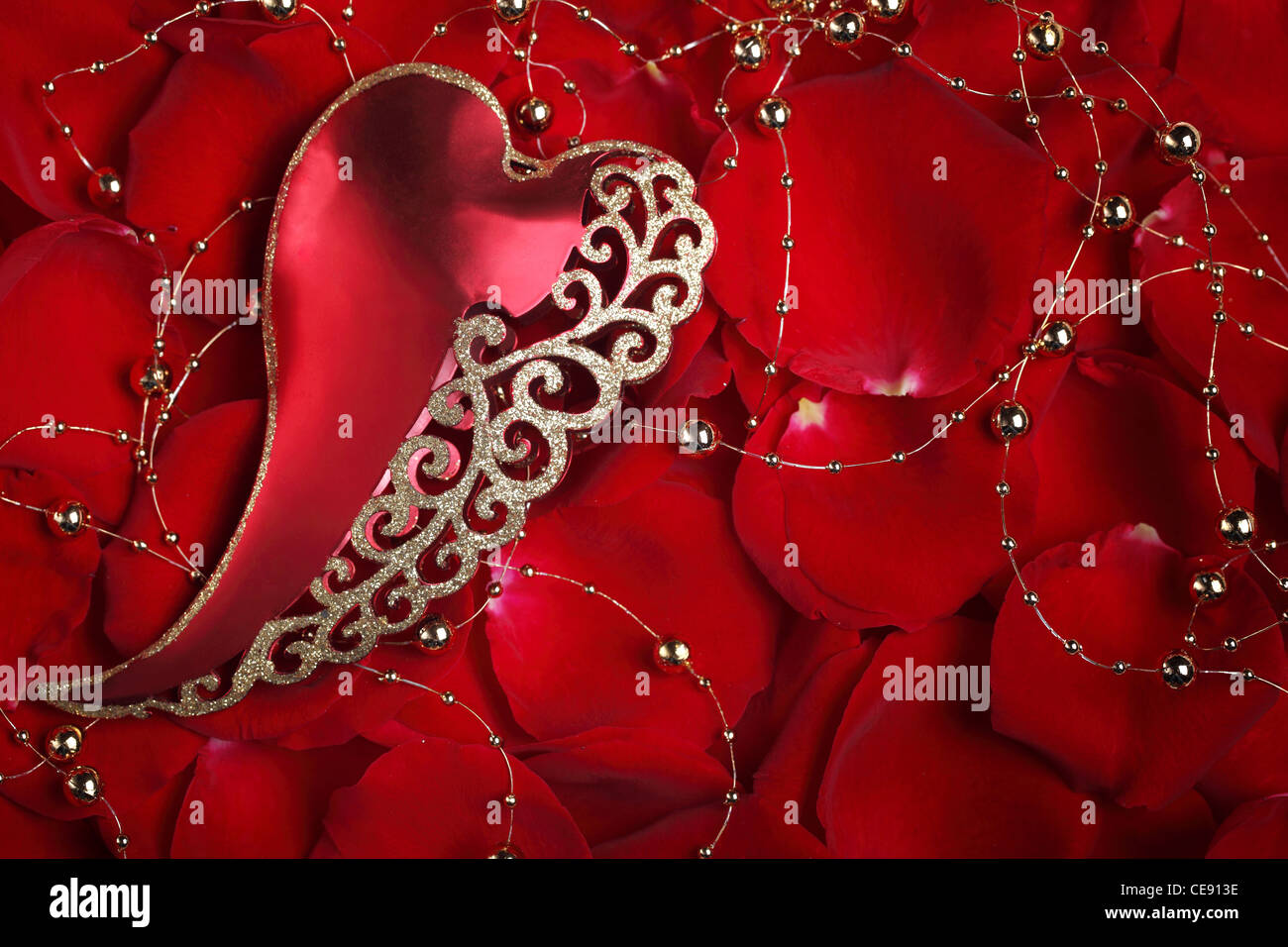 Valentine Herz Form Ornament auf Rosenblättern Hintergrund Stockfoto