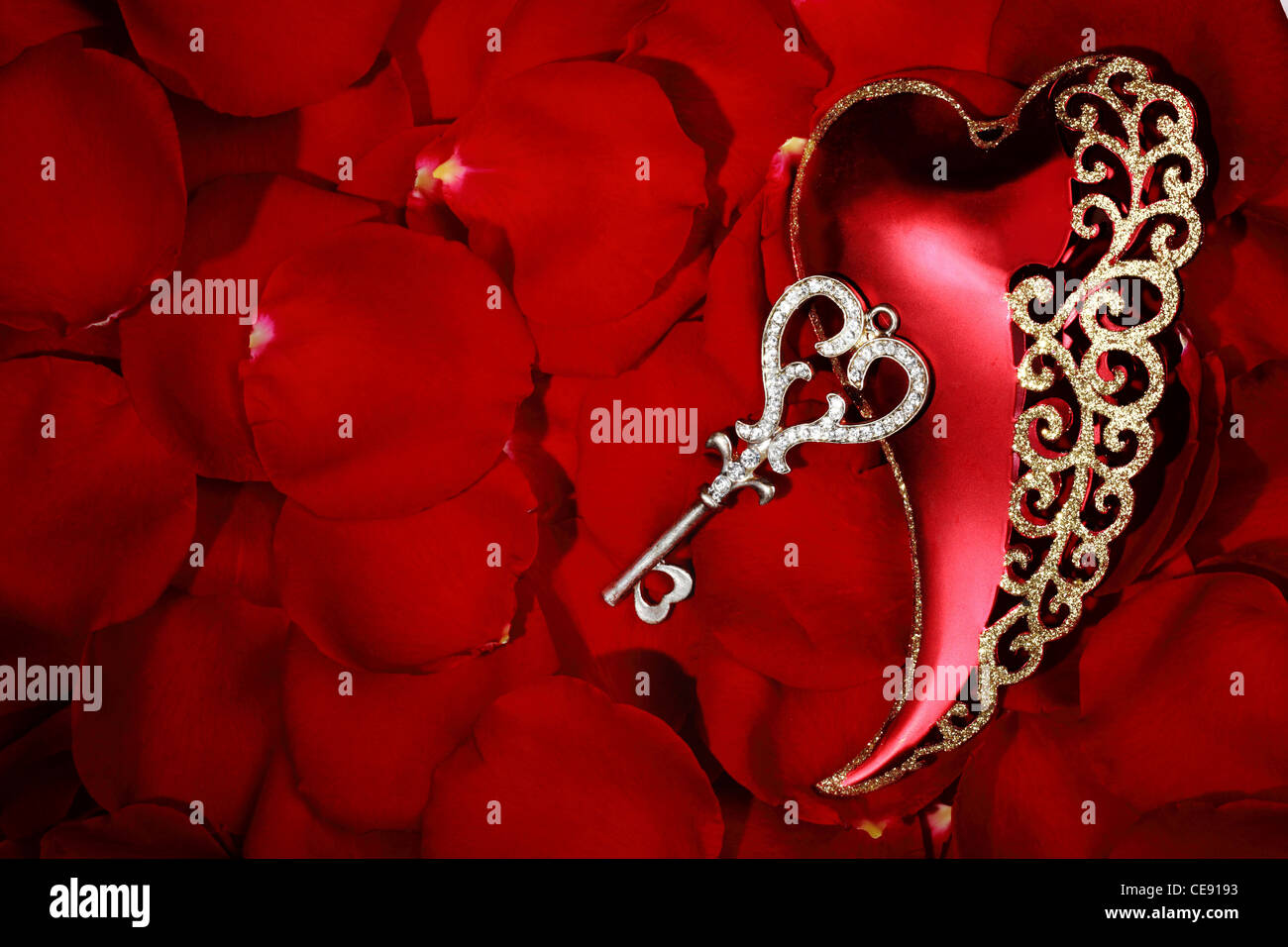 Valentinstag Herz Form Ornament mit Schlüssel auf Rosenblättern Hintergrund Stockfoto
