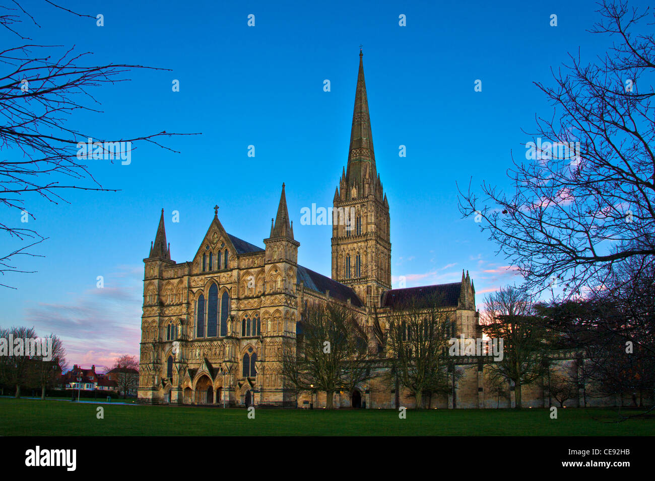 Dämmerung fällt über der Westfront und Turm der mittelalterlichen Kathedrale von Salisbury, Wiltshire, England, UK Stockfoto