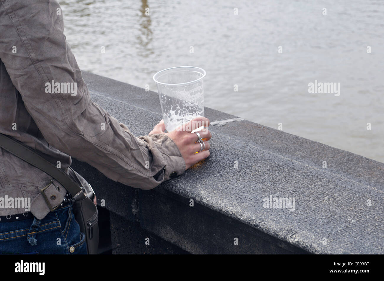 Frau, die ein Glas Bier auf der Brücke hält, Prag, Tschechien Stockfoto
