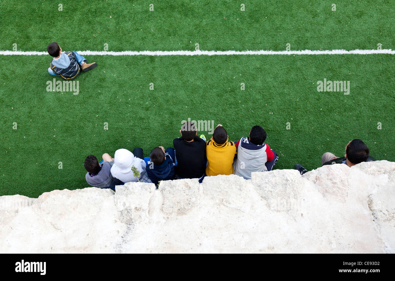 Draufsicht der jungen von der Seitenlinie aus zusehen, wie ihre Freunde Fußball in Jerusalem spielen. Stockfoto