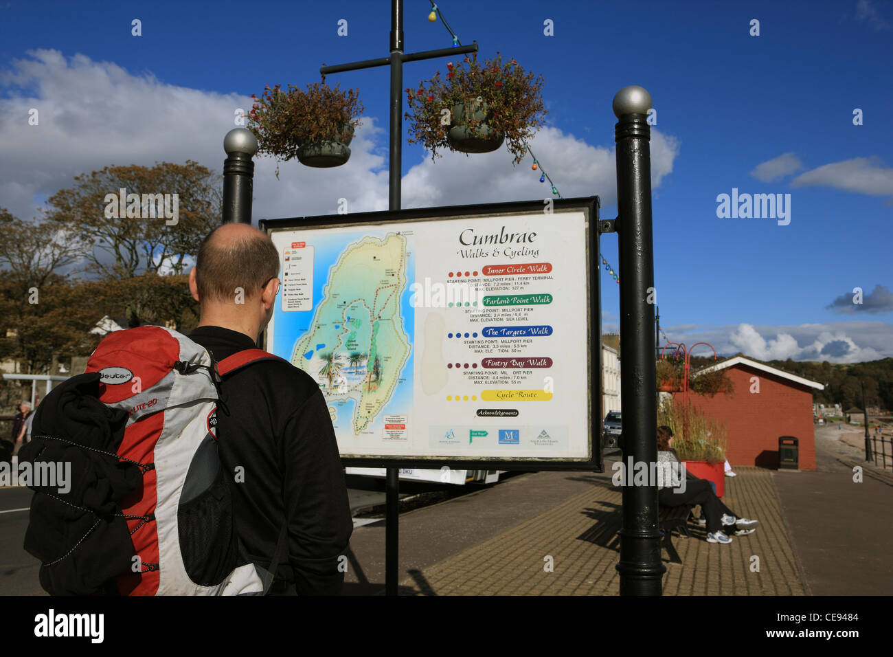 Mann, Blick auf die Karte der Cumbrae und die Wanderung leitet Informationen in Millport Stockfoto