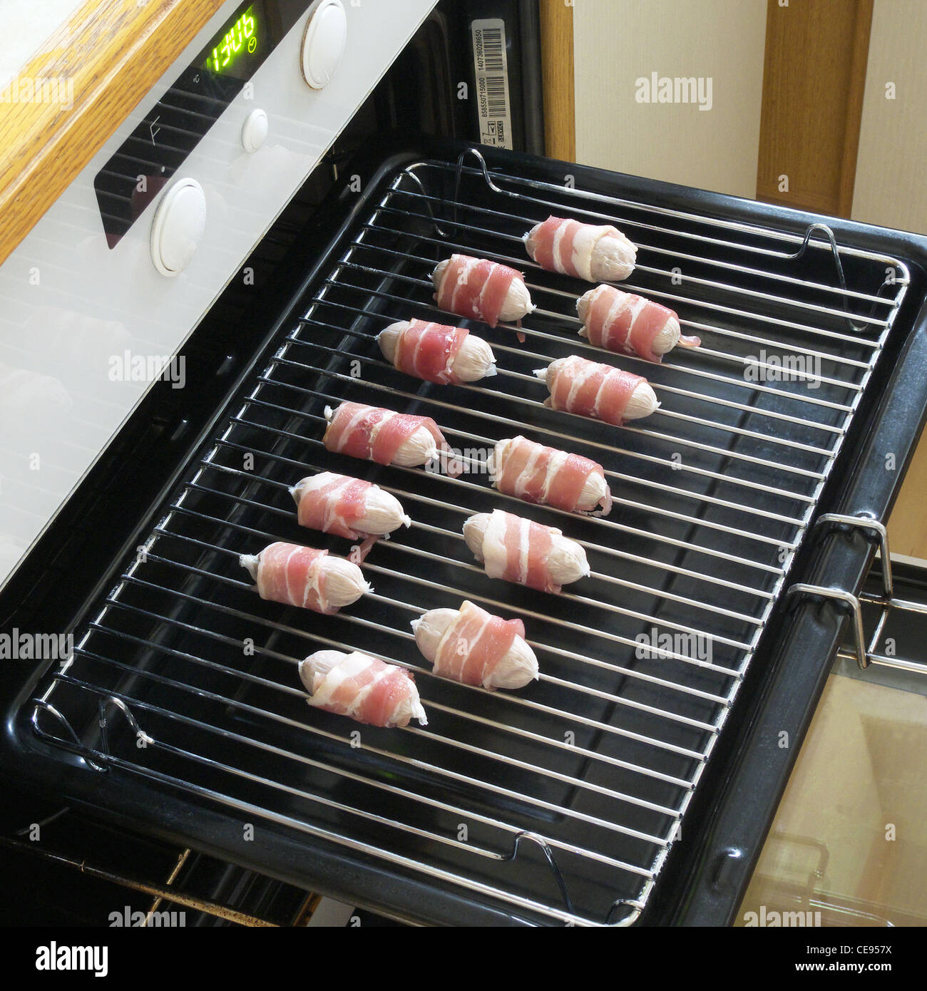 Ungekocht Schweine In decken (eingewickelt in Speck Würstchen) auf einem Grill Pan Stockfoto