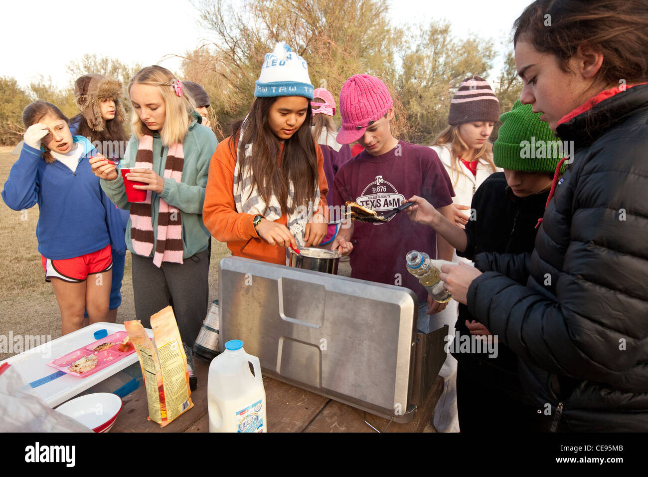 Mittelschule Klassenfahrt zum Big Bend National Park in Texas. Studenten kochen Frühstück mit Pfannkuchen in einem camp Stil Herd Stockfoto